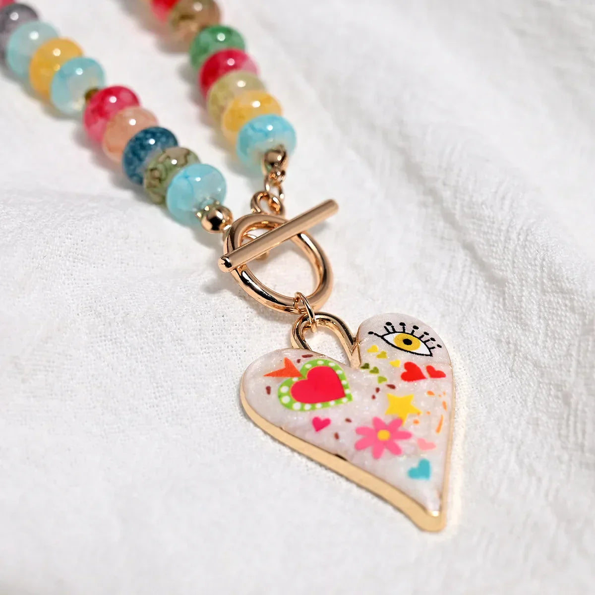 Collar de cuentas de piedras preciosas multicolor con colgante de corazón pintado.