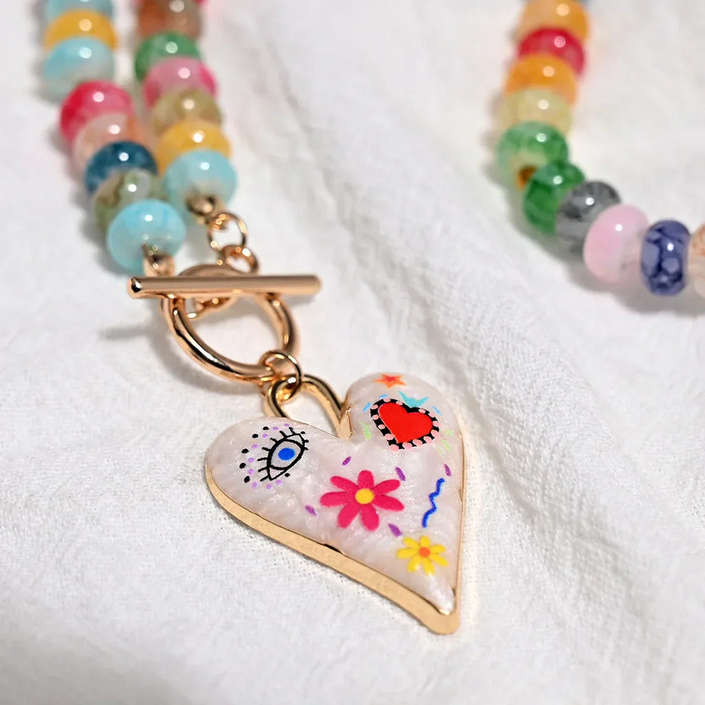 Collar de cuentas de piedras preciosas multicolor con colgante de corazón pintado.